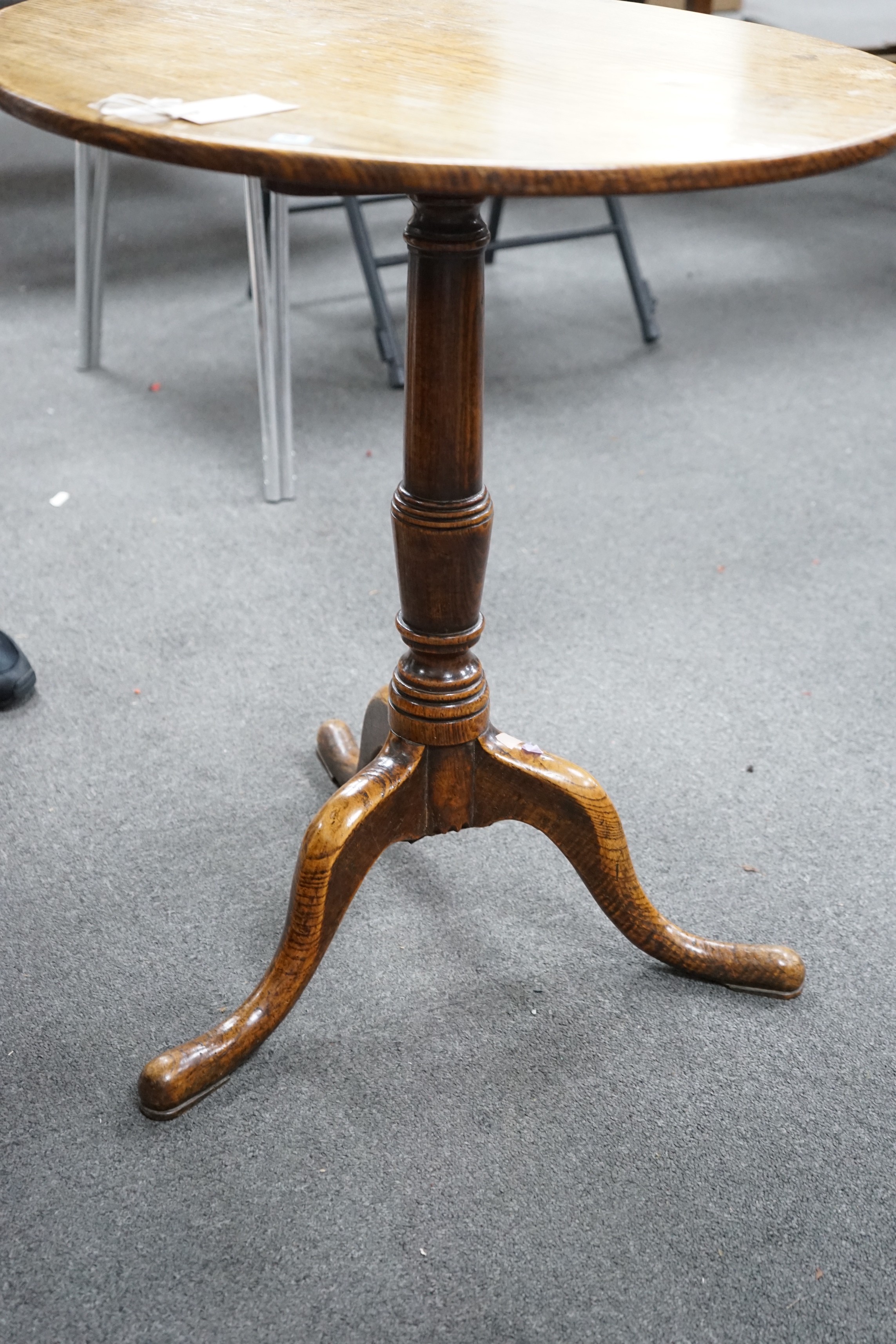 A George III circular oak tripod tilt top tea table on turned column, diameter 58cm, height 67cm